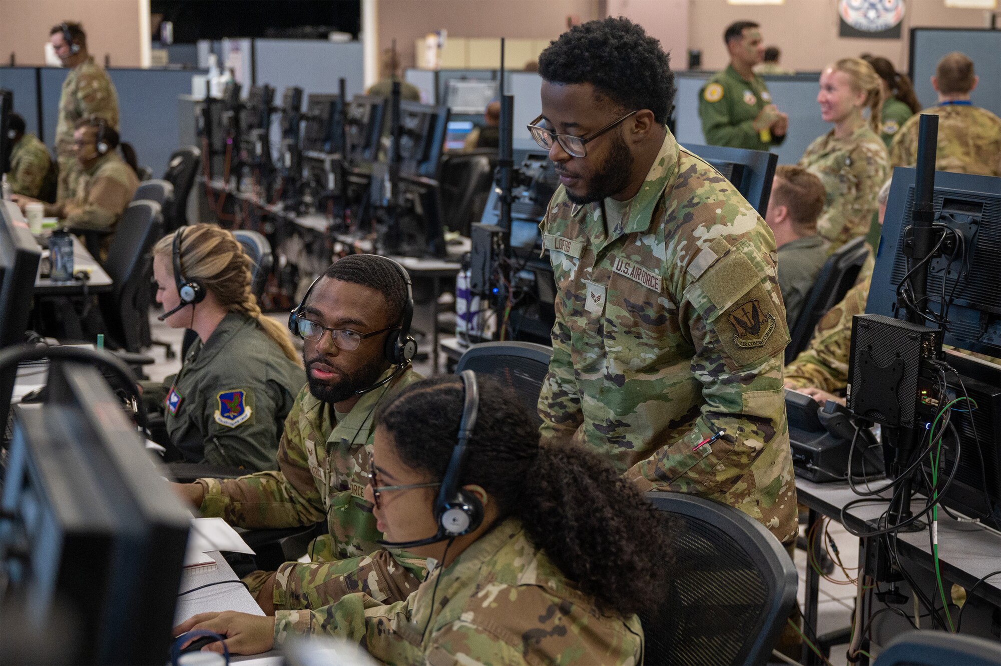 uniformed U.S. Airmen work at computers