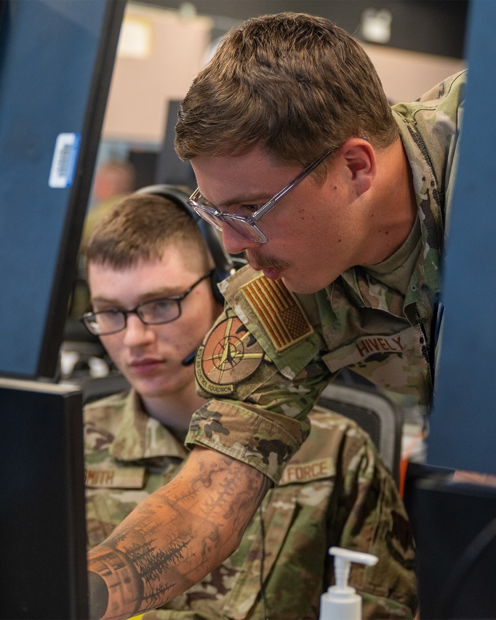 uniformed U.S. Airmen work at computers