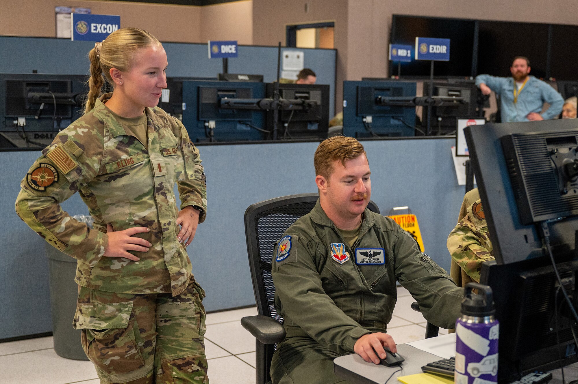 uniformed U.S. Airmen work at computers