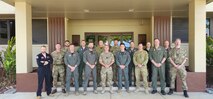 Royal Air Force and Royal Australian Air Force members stand outside of a building