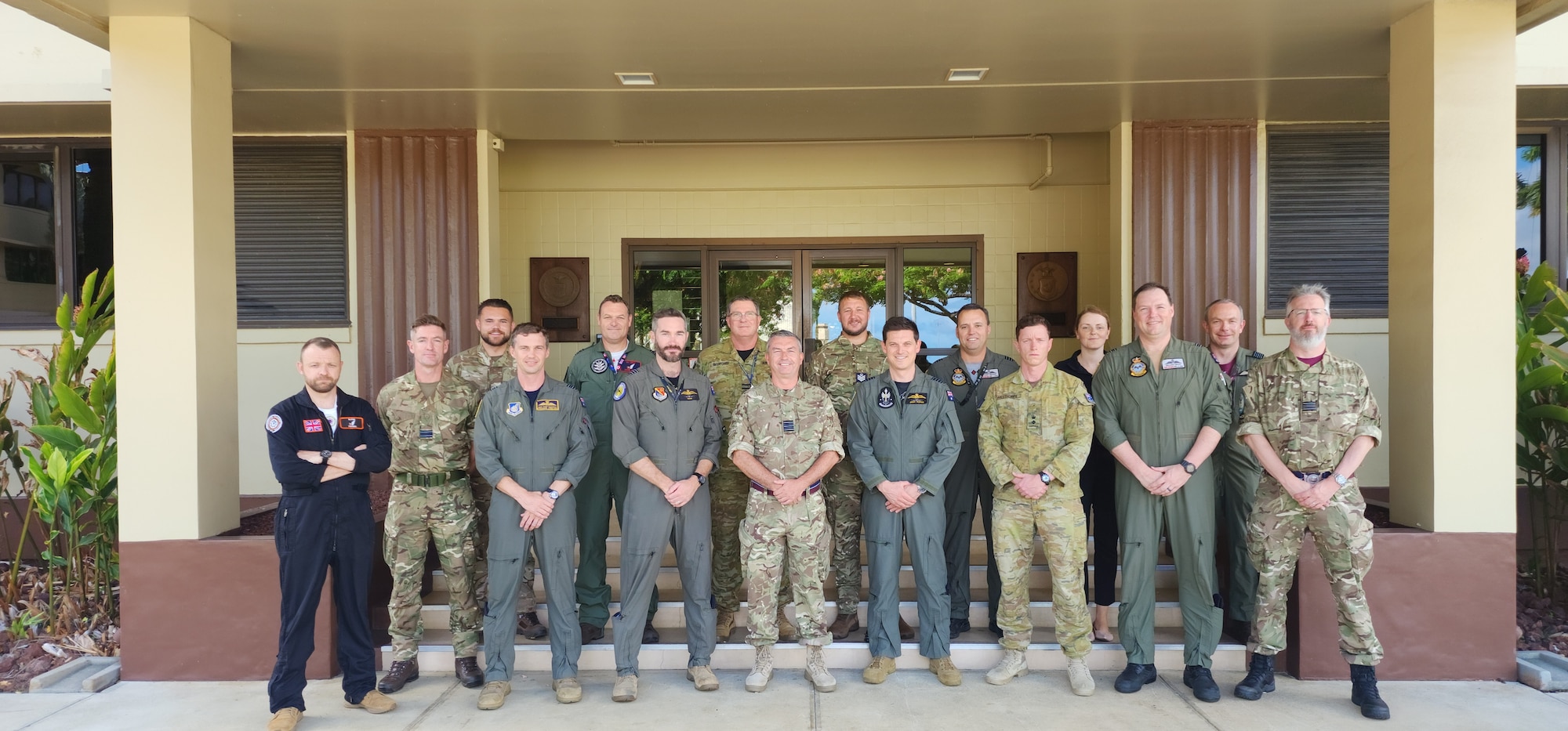 Royal Air Force and Royal Australian Air Force members stand outside of a building
