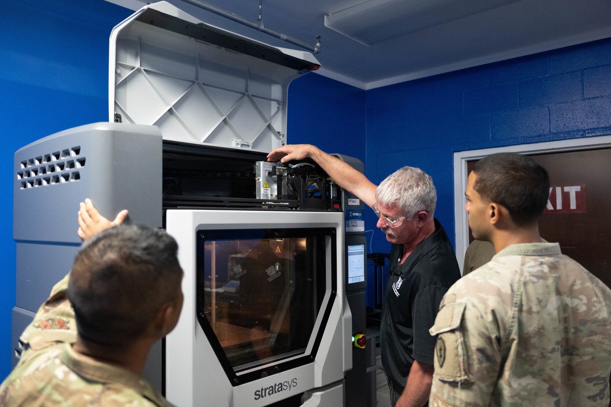 U.S. Air Force and U.S. Army personnel watch an instructor give a lesson on the 3D printer used to print tools and parts on Joint Base Pearl Harbor-Hickam, Hawaii.