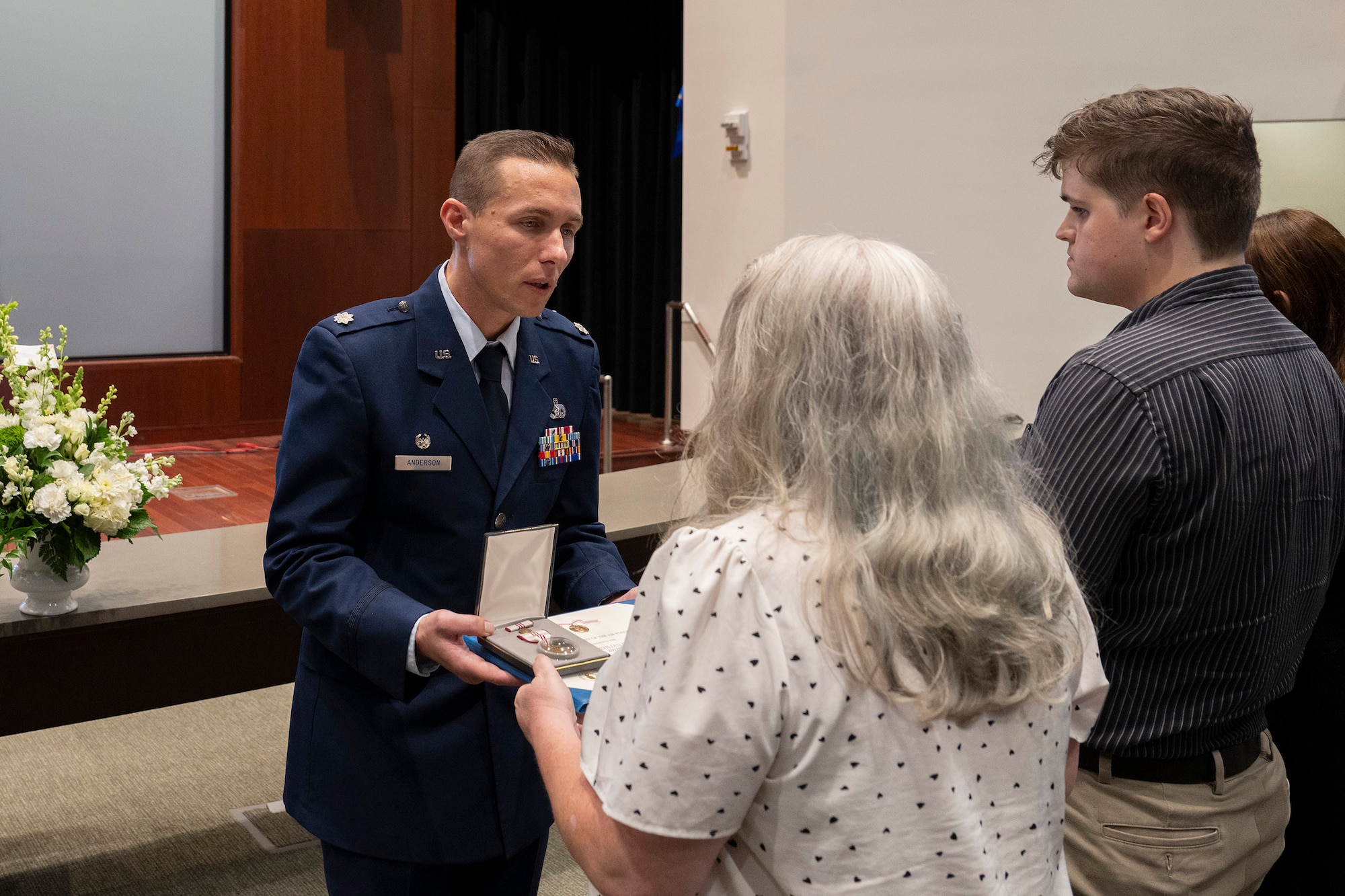 Lt. Col. Anthony Anderson, commander of the 709th Support Squadron, Patrick Space Force Base, Fla., presents the posthumous Outstanding Civilian Career Service Award to Jennifer Paynter, wife of the late David A. Paynter, who served as Anderson’s deputy director.  Anderson and members of the Air Force Technical Applications Center held a memorial service in Paynter’s honor Aug. 11.  Also pictured is David’s son, Sam.   (U.S. Air Force photo by Matthew S. Jurgens)