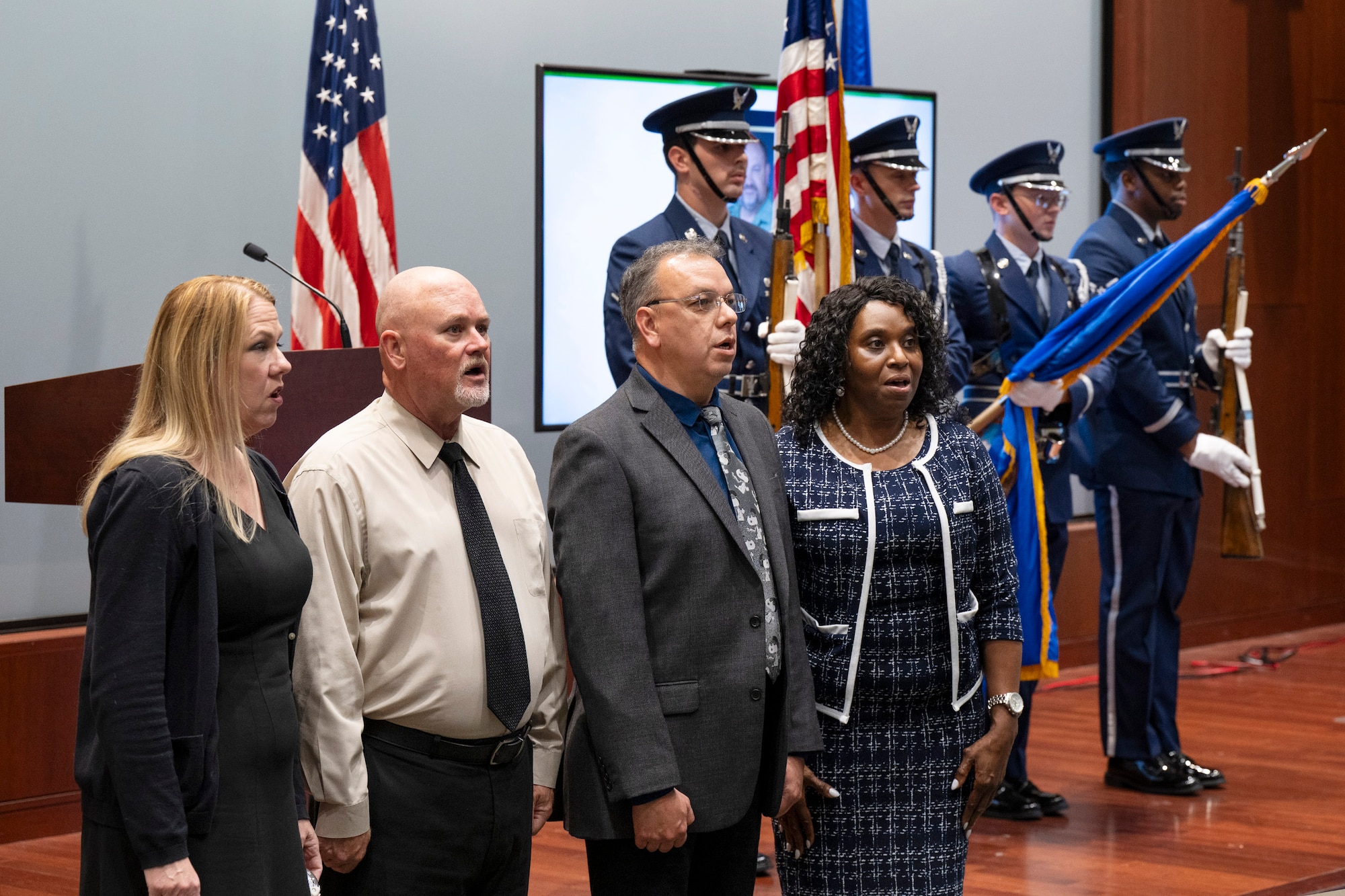 Atomic Blue, the a cappella choral group made of up volunteers from the Air Force Technical Applications Center, Patrick Space Force Base, Fla., perform the National Anthem as the Honor Guard presents the colors.  The vocalists performed at a memorial service for David A. Paynter, A-4 Director of Logistics and deputy director for the 709th Support Squadron, who passed away May 12.    (U.S. Air Force photo by Matthew S. Jurgens)