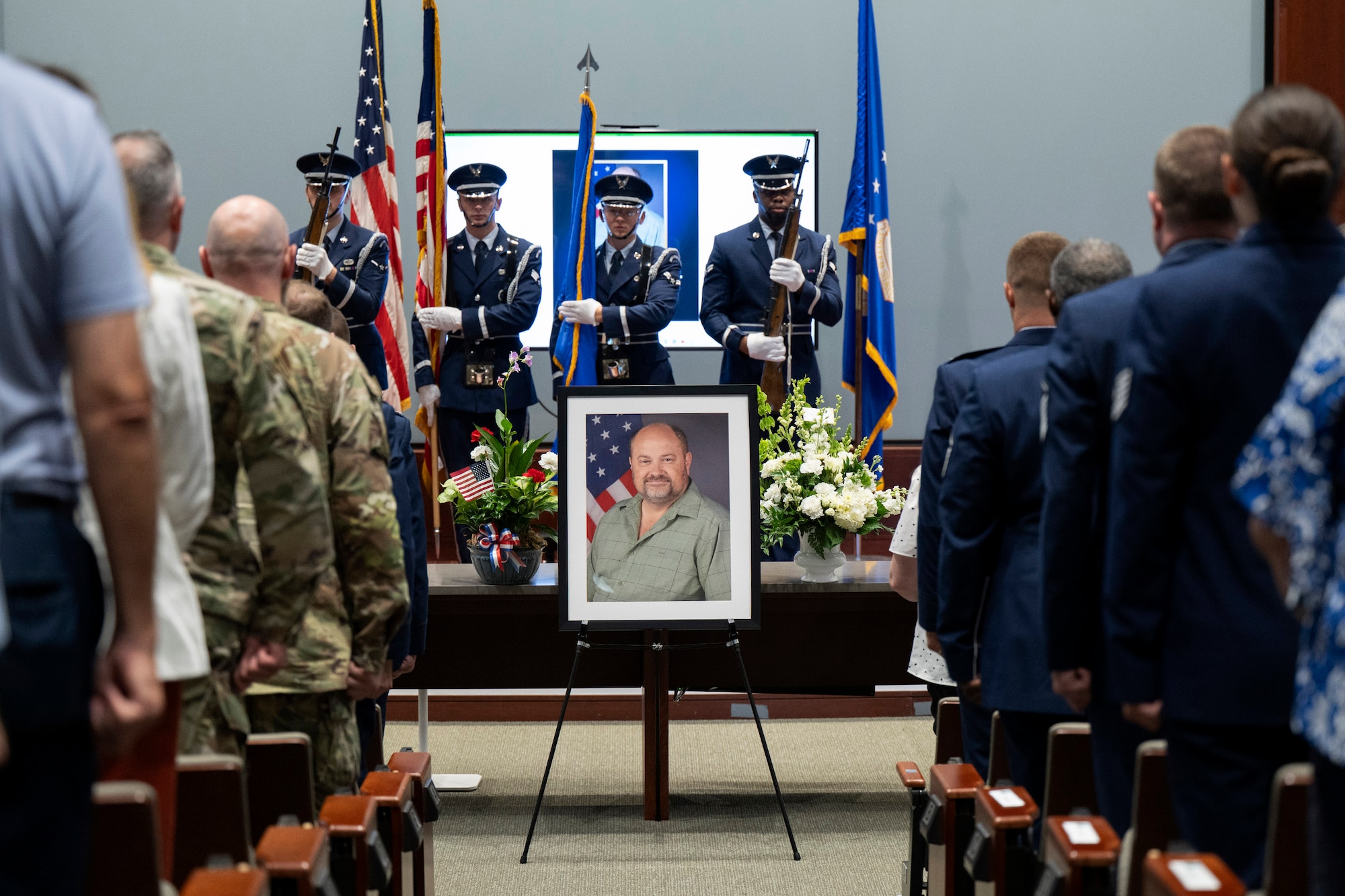 Members of the Air Force Technical Applications Center stand at attention as Honor Guardsmen present the colors at a memorial service for David A. Paynter, A-4 Director of Logistics and deputy director for the 709th Support Squadron at Patrick Space Force Base, Fla.  Paynter passed away suddenly May 12 and the center invited his family to join them in recognizing and remembering his contributions to the Air Force.  (U.S. Air Force photo by Matthew S. Jurgens)