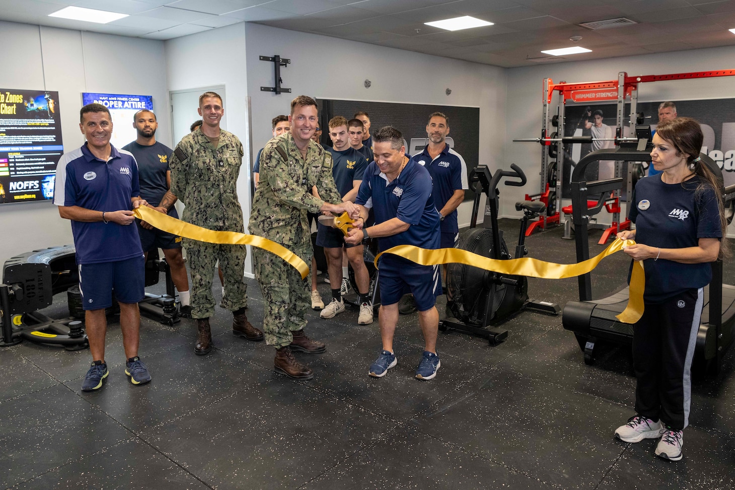 Capt. Stephen Steacy, commanding officer, Naval Support Activity  Souda Bay; Morale, Welfare and Recreation (MWR) Fitness Center employees; and Sailors assigned to NSA Souda Bay cut a ribbon during a ceremony for the opening of the MWR Fitness Center’s new Navy Operational Fitness and Fueling System (NOFFS) Zone strength area on Aug. 14, 2025.