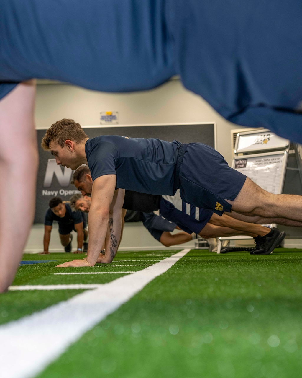 Sailors assigned to Naval Support Activity Souda Bay lift weights during a ceremony for the opening of the Morale, Welfare and Recreation Fitness Center’s new Navy Operational Fitness and Fueling System (NOFFS) Zone strength area on Aug. 14, 2025.