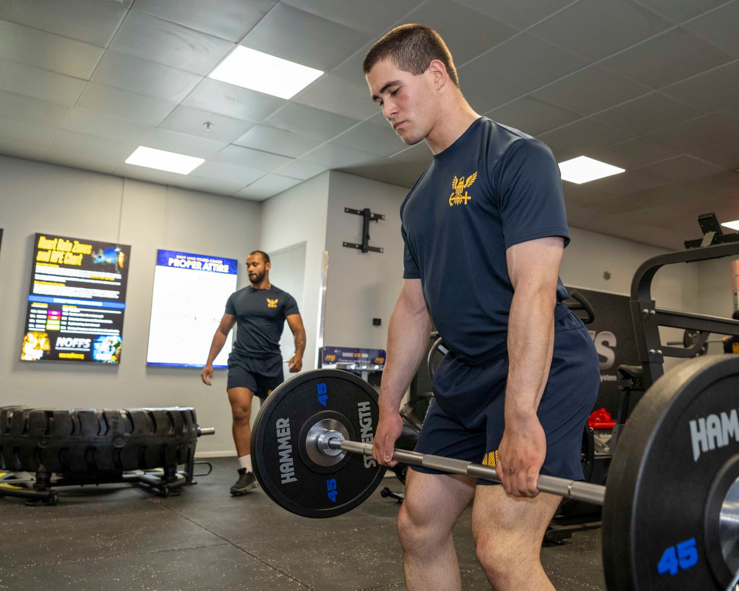 Sailors assigned to Naval Support Activity Souda Bay lift weights during a ceremony for the opening of the Morale, Welfare and Recreation Fitness Center’s new Navy Operational Fitness and Fueling System (NOFFS) Zone strength area on Aug. 14, 2025.