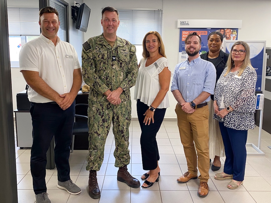 Members of the Naval Support Activity (NSA) Souda Bay Navy Federal Credit Union team pose with Capt. Stephen Steacy, commanding officer, NSA Souda Bay, in celebration of being awarded the Department of the Navy Distinguished Credit Union of the Year award onboard NSA Souda Bay, Greece, on Aug. 8 2025.