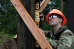 Alaska Army National Guard Spc. David Krepel, assigned to the 910 Engineer Support Company, conducts measurements for a bunker at Observation Post Fagan on Joint Base Elmendorf-Richardson Aug. 7, 2025, enhancing  the training site for the U.S. Army’s 11th Airborne Division. The project marked the first time the unit’s horizontal and vertical engineering platoons combined efforts, showcasing their ability to move earth and construct shelters as one team. (Alaska Army National Guard photo by Seth LaCount)