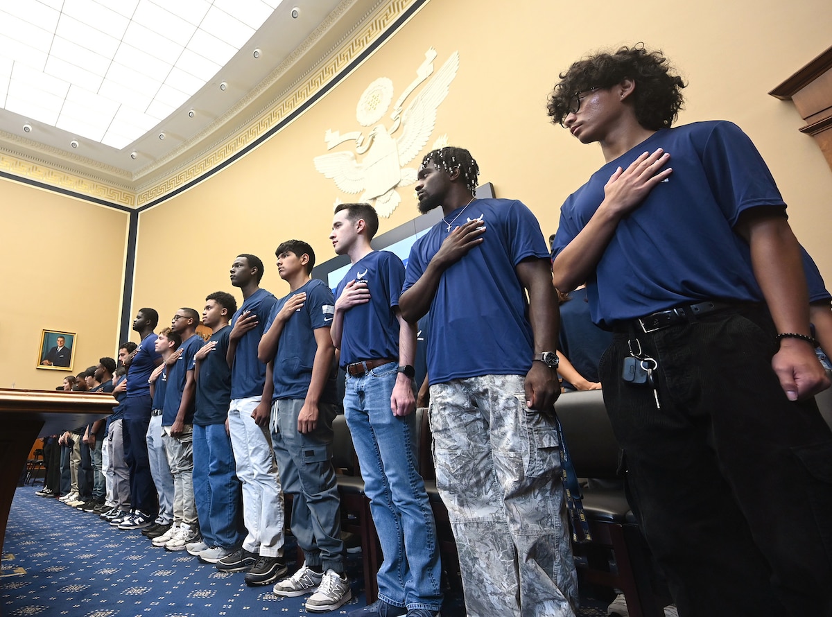 Members of the Delayed Entry Program place their hands over their hearts as the National Anthem plays.