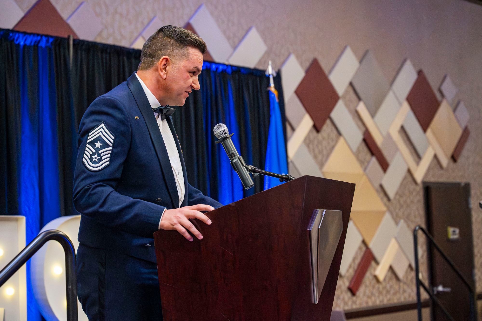 U.S. Air Force Chief Master Sgt. James Wilfong, Air Forces Southern command chief, delivers the charge to the inductees during the Senior Noncommissioned Officer Induction ceremony in Tucson, Arizona, Aug. 15, 2025. The charge outlines the responsibilities, expectations and leadership duties of SNCOs as they step into greater roles within the Air Force. (U.S. Air Force photo by Airman 1st Class Samantha Melecio)