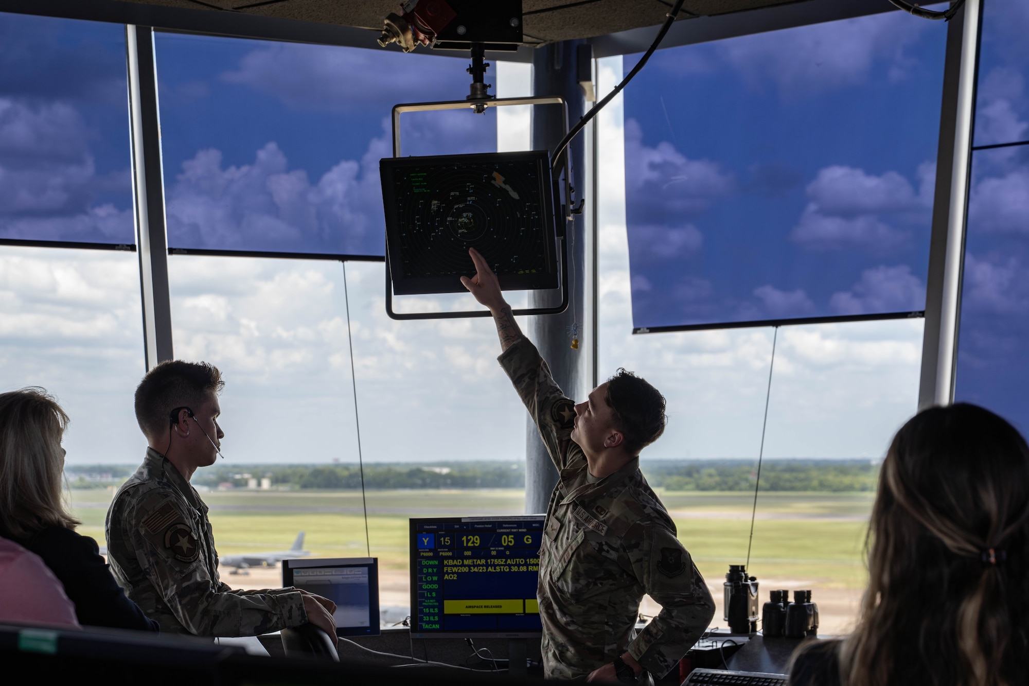 U.S. Air Force Airman 1st Class Jacob Rogers, 2nd Operations Support Squadron air traffic control apprentice, explains how the ATC tower works to honorary commanders