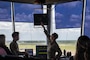 U.S. Air Force Airman 1st Class Jacob Rogers, 2nd Operations Support Squadron air traffic control apprentice, explains how the ATC tower works to honorary commanders