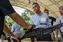 Danny Aiello, Aviation Tech Group manager and 2nd Maintenance Group honorary commander, listens to a Combat Arms Training and Maintenance Airman talk about their weaponry
