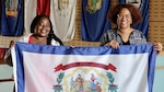 two women hold up flag
