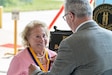 Helen Duer, family member of U.S. Army Capt. Bee Rife Osborne, receives the gold Order of St. Michael award at the 110th anniversary celebration of Kentucky Army National Guard aviation, held at the Army Aviation Support Facility on Boone National Guard Center in Frankfort, Kentucky, Aug. 15, 2025.