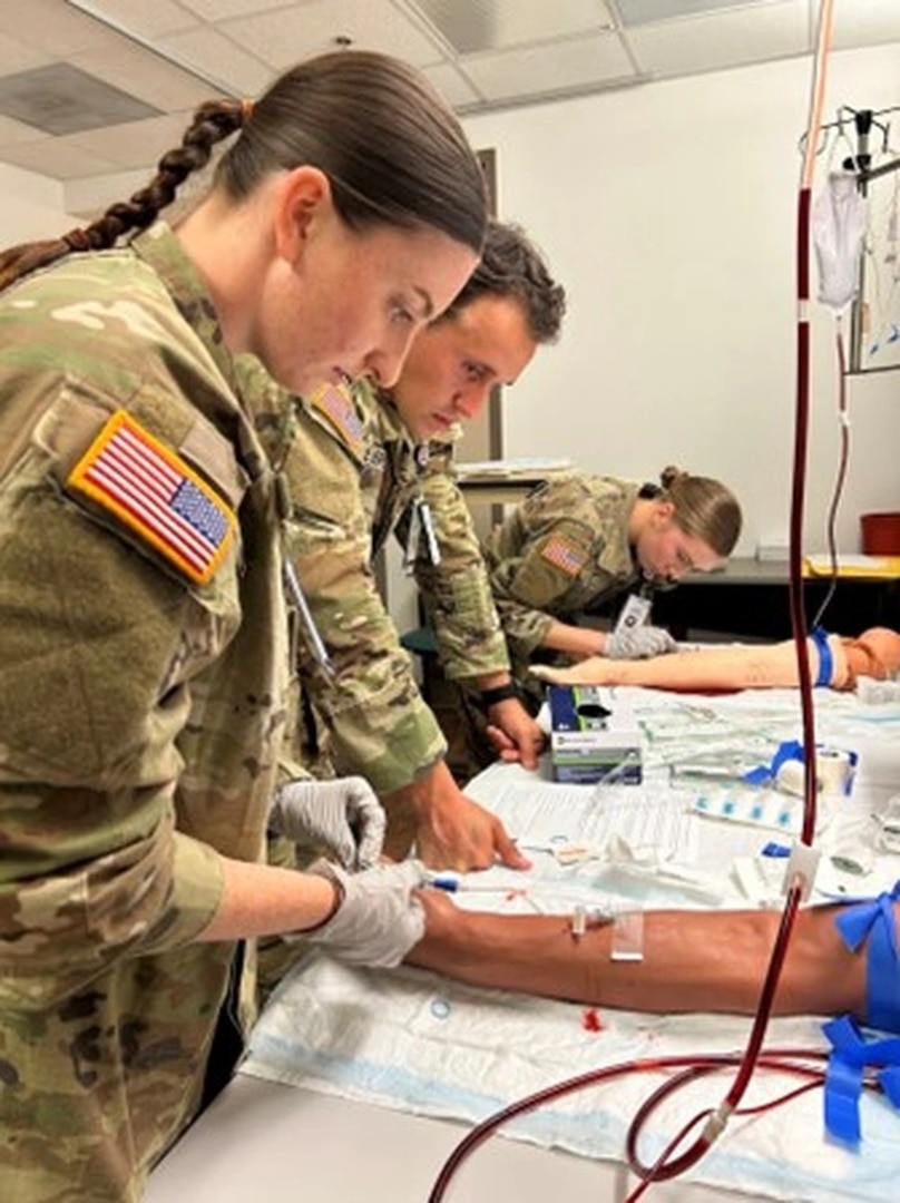 Cadet Olivia Adamson, Cadet John Lopes, and Cadet Molly Cochran focus intently during the simulation lab.