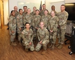 All smiles on graduation day (From Left to Right: Back row: Col. Donald Kimbler, Cadet John Lopes, Cadet Priscilla Wright, Cadet Jakob Feaster, Maj. Cameron Player, Col. Guy St. Louis; Middle row: Capt. Carmen Williams, Cadet Nyah Marzan, Cadet Madison Miller, Cadet Nicole Narciso, Cadet Olivia Adamson, Cadet Molly Cochran; Kneeling: 1st Lt. Keely Aliseo, 1st Lt. Kathryn Anderson)