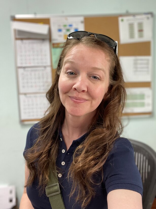 A lady smiling for a selfie in her office.