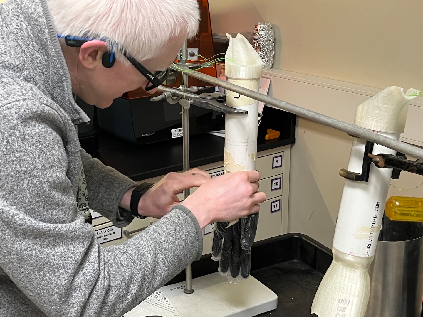 To extend the life of their 3D hand model used in glove testing, PTC engineer Edward Dalton applies a layer of rubber and plastic gloves. This acts as a barrier, preventing wear and tear from the fuel.