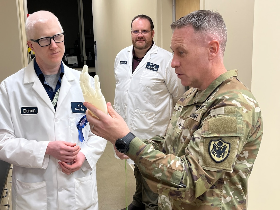 PTC engineer Edward Dalton and PTC Supervisory Chemist Mike McClain explain the 3D hand model concept to Troop Support Commander Army Brig. Gen. Sean P. Kelly during his PTC Analytical tour in July 2025.