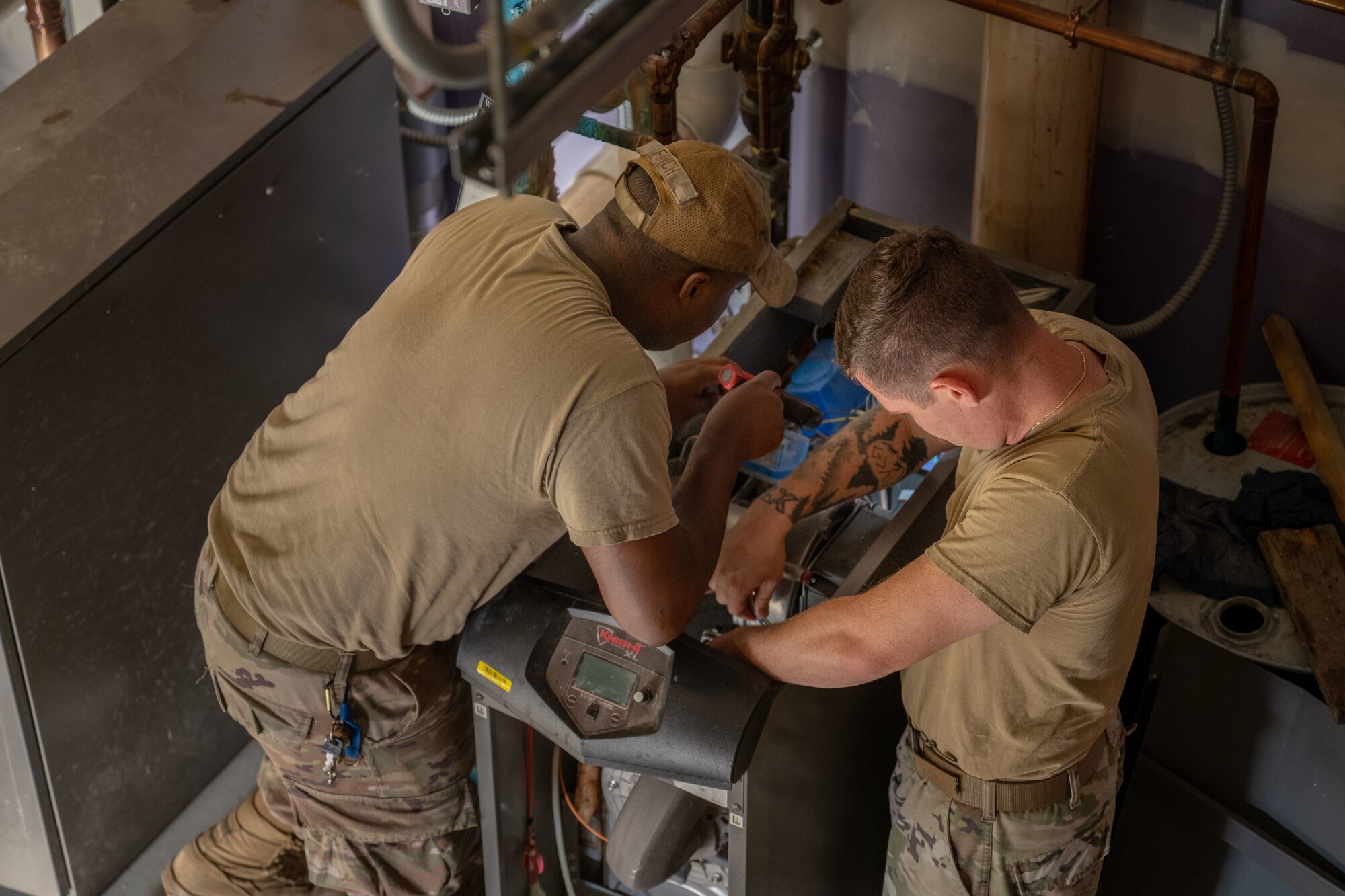 From left, Senior Airman Kelby Finch and Staff Sgt. Daniell Blade, 22nd Civil Engineer Squadron heating, ventilation and air conditioning technicians, reassemble a boiler after inspection at McConnell Air Force Base, Kansas, Aug. 19, 2025. Inspections are done on a routine basis to ensures the unit works safely and efficiently. (U.S. Air Force photo by Airman 1st Class Paula Arce)
