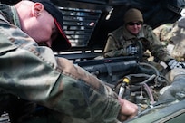 Maryland Air National Guard Staff Sgt. Jonathan Bandy, a vehicle mechanic with the 175th Logistics Readiness Squadron, observes a civilian member of the Armed Forces of Bosnia and Herzegovina conduct engine maintenance during a convoy from Zenica to Visoko, in Kakanj, Bosnia and Herzegovina, April 7, 2025.
