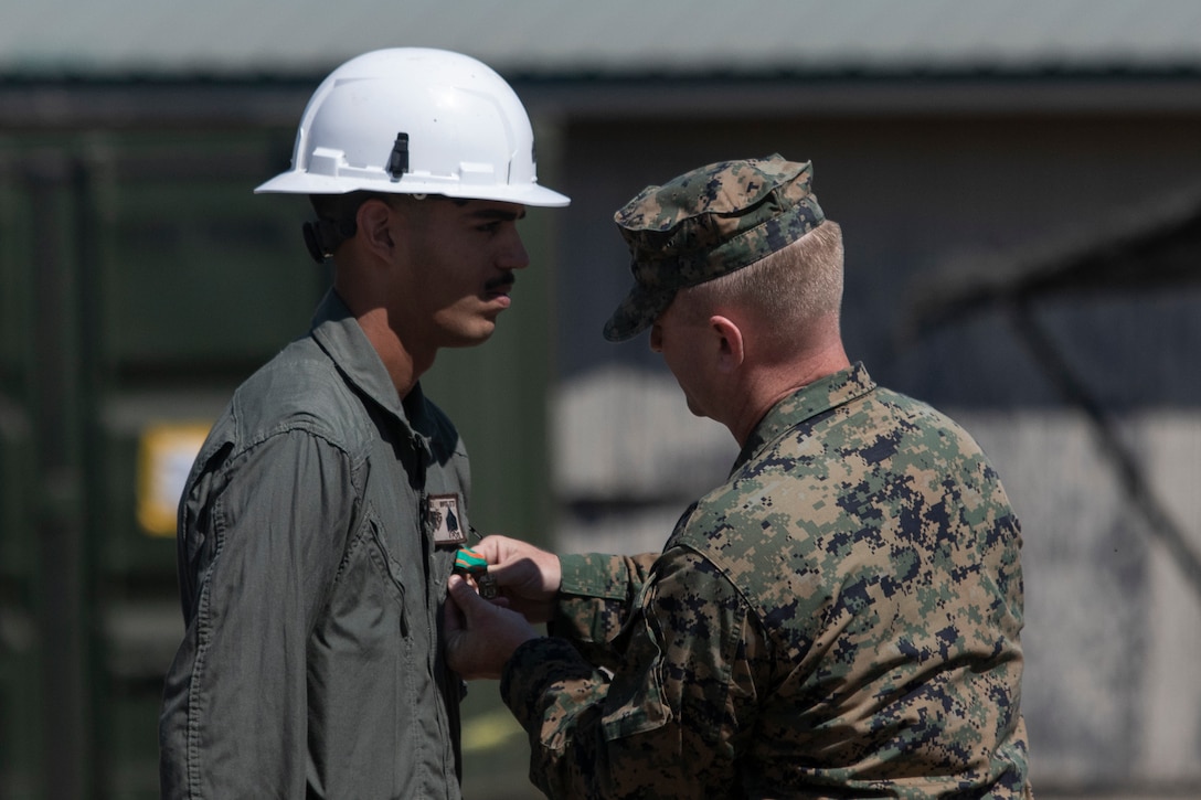 U.S. Marine Corps Lt. Col. Chad T. Fitzgerald, right, the commanding officer of Marine Wing Support Squadron 372, Marine Air Control Group 38, 3rd Marine Aircraft Wing, awards the Navy and Marine Corps Achievement Medal to Sgt. Hayden Gowin, a combat engineer with MWSS-372, during Operation Resilient Spear at Vandenberg Space Force Base, California, Aug. 10, 2025. Operation Resilient Spear is an opportunity for Marines with MWSS-372 to integrate and train with Naval Mobile Construction Battalion 5, Naval Construction Force, through Base Recovery After Attack and Airfield Damage Repair Training to increase interoperability between Marine Corps engineers and Navy Seabees. Fitzgerald is a native of Pennsylvania, and Gowin is a native of New York. (U.S. Marine Corps photo by Lance Cpl. Alexander Vaughn)