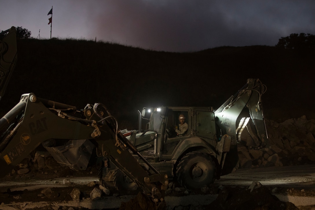 A U.S. Navy Sailor with Airfield Construction Company Bravo, Naval Mobile Construction Battalion 5, Naval Construction Force, operates a backhoe loader during Operation Resilient Spear at Vandenberg Space Force Base, California, Aug. 10, 2025. Operation Resilient Spear is an opportunity for Marines with Marine Wing Support Squadron 372, Marine Air Control Group 38, 3rd Marine Aircraft Wing, to integrate and train with NMCB-5 through Base Recovery After Attack and Airfield Damage Repair Training to increase interoperability between Marine Corps engineers and Navy Seabees. (U.S. Marine Corps photo by Lance Cpl. Alexander Vaughn)