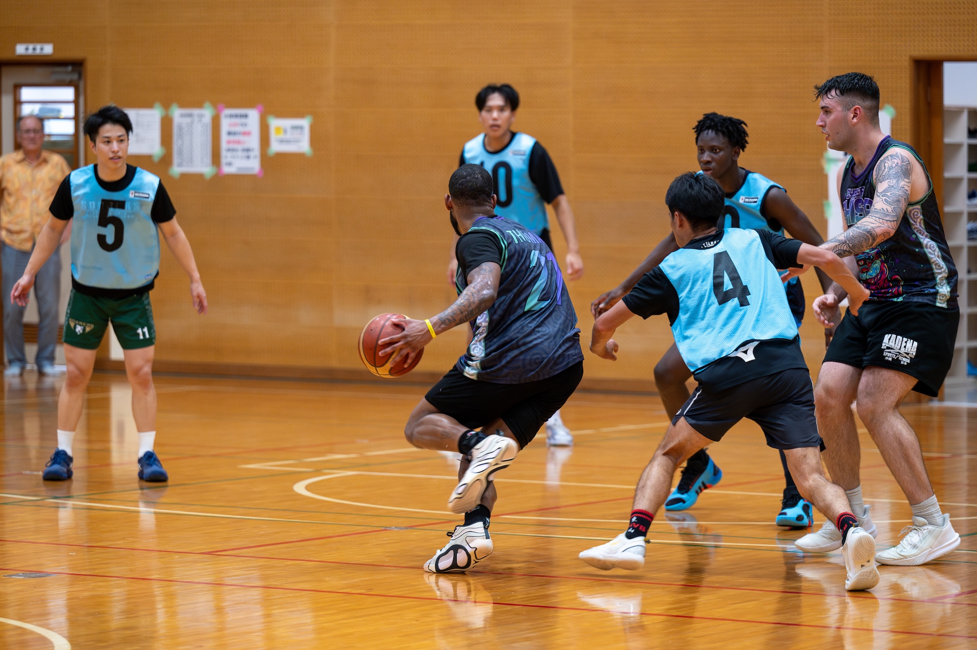 An Airman with 18 CS breaks through the defensive line of the opposite team during a basketball match
