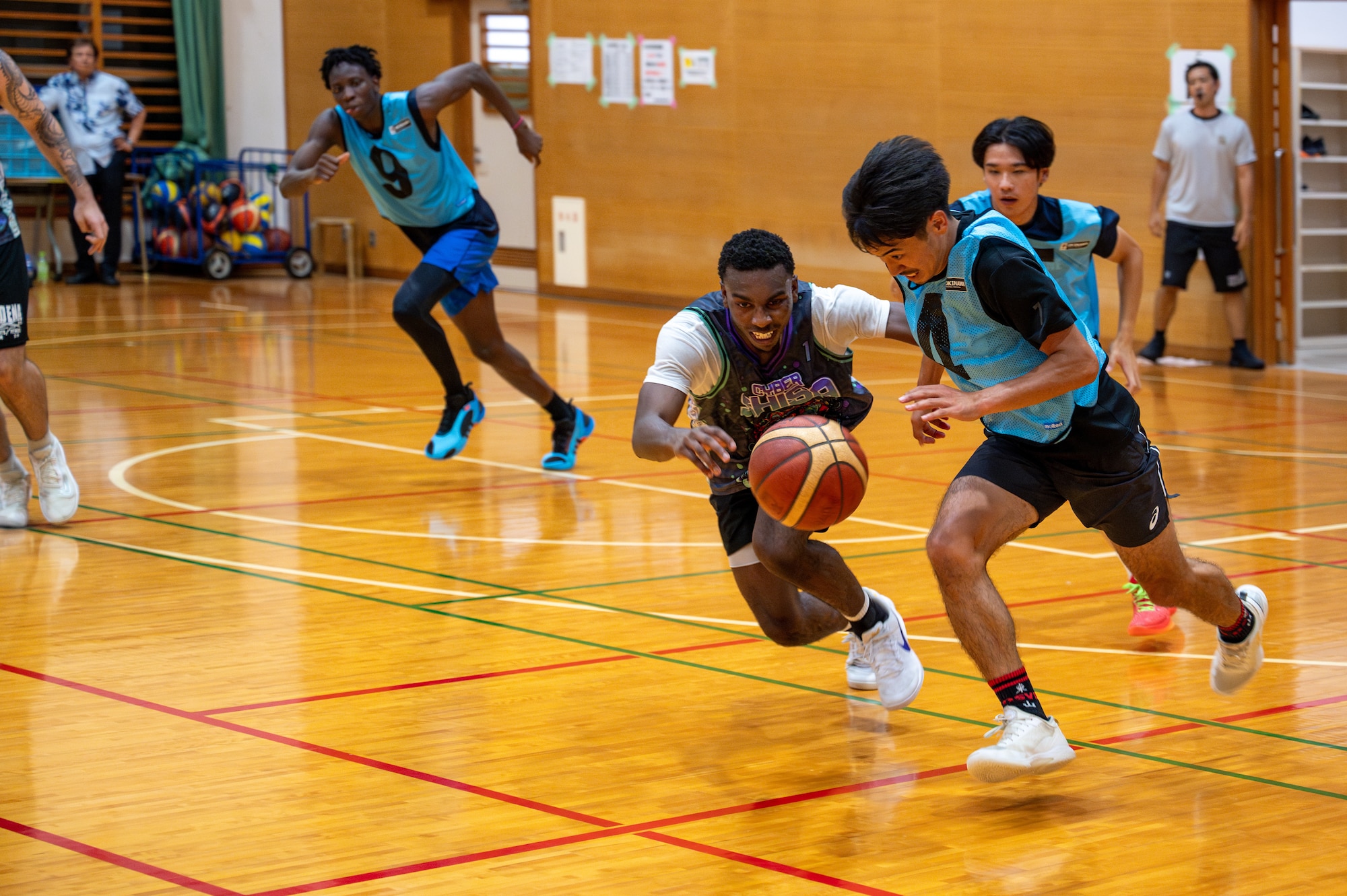 Two basketball players fight over the ball