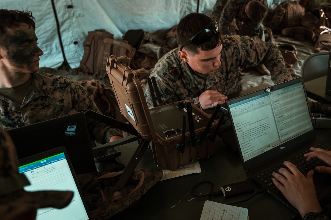 Marines with II Marine Expeditionary Force Communication Strategy and Operations use a 5G expeditionary transmission system during a field training exercise at Camp Lejeune, N.C., May 21, 2025. The system enables forward-deployed units to securely transmit high-resolution imagery and video in real time from austere environments. The training allowed Marines to evaluate the system’s speed, reliability, and ease of use under realistic operational conditions. (Official Marine Corps Systems Command photo by Joel Rivera-Camacho) (This photo has been altered to remove implied endorsement by blurring a company logo.)