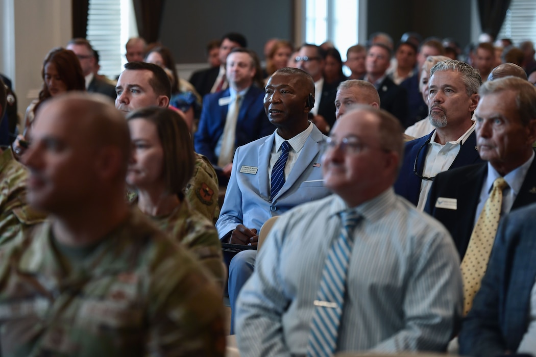 A group of attentive people sit within an audience.