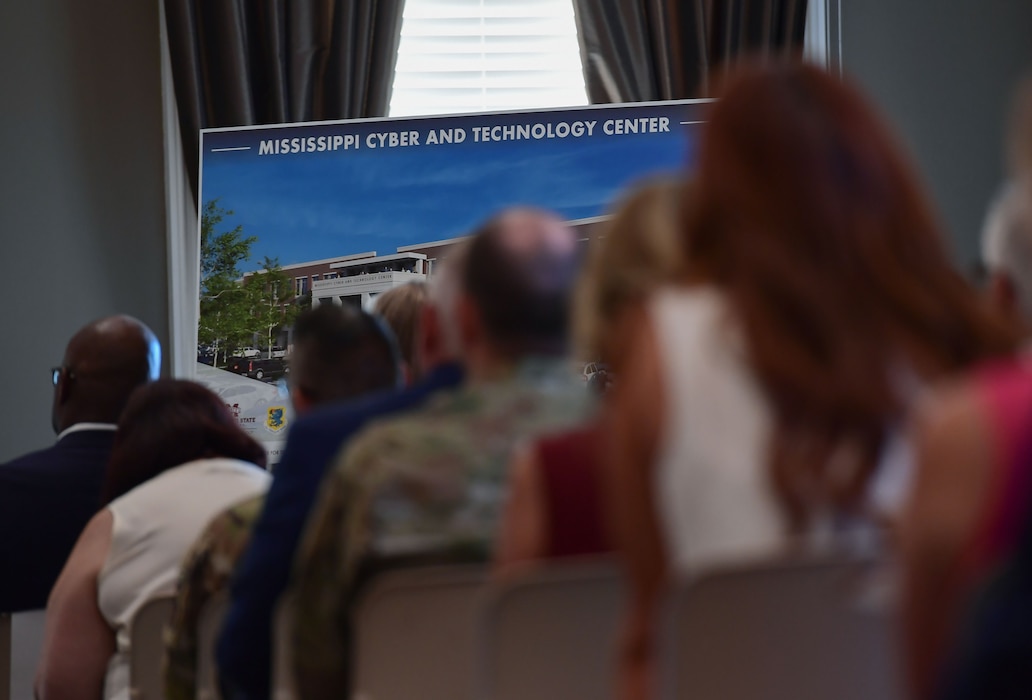 A poster is on display in front of an audience.