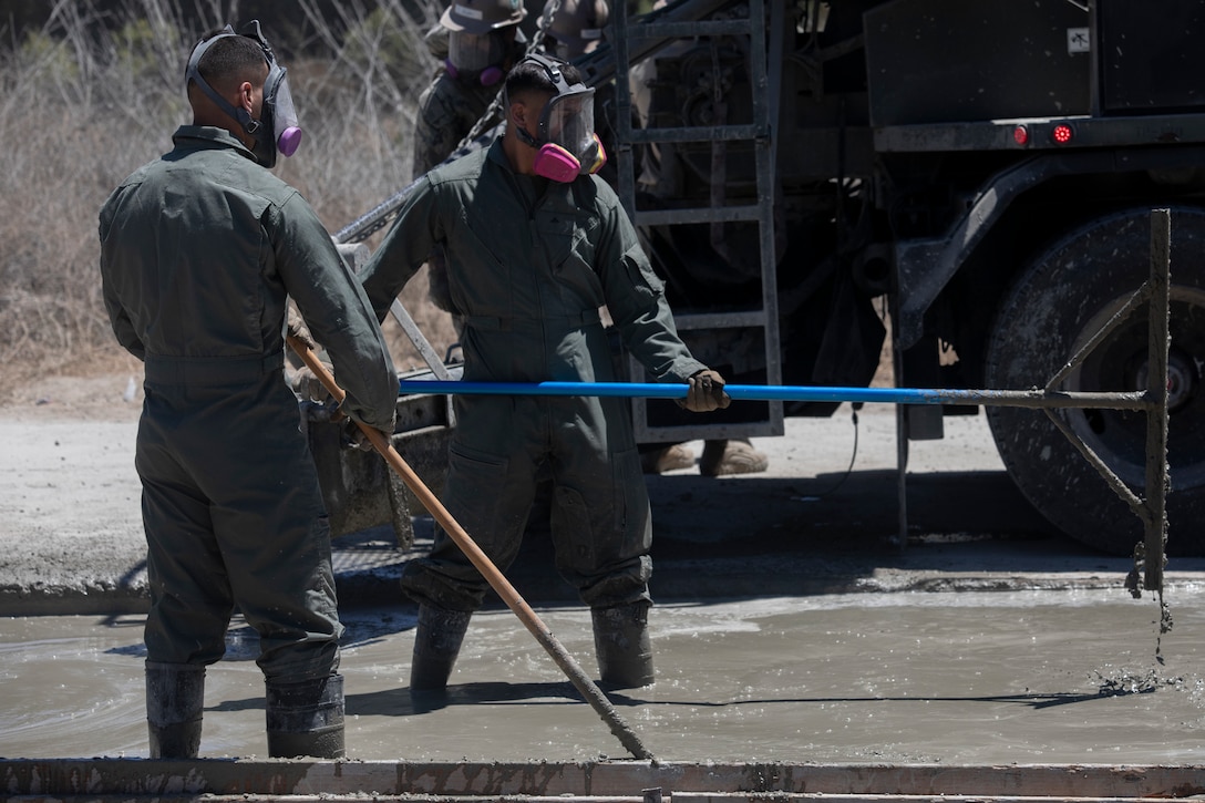 U.S. Marine Corps Lance Cpl. Bernardo Rodrigues Campos, left, a combat engineer, and Lance Cpl. Cristian Estrada, a combat engineer, both with Marine Wing Support Squadron 372, Marine Air Control Group 38, 3rd Marine Aircraft Wing, rake concrete during Operation Resilient Spear at Vandenberg Space Force Base, California, Aug. 8, 2025. Operation Resilient Spear is an opportunity for Marines with MWSS-372 to integrate and train with Naval Mobile Construction Battalion 5, Naval Construction Force, through Base Recovery After Attack and Airfield Damage Repair Training to increase interoperability between Marine Corps engineers and Navy Seabees. Rodrigues Campos is a native of Brazil, and Estrada is a native of California. (U.S. Marine Corps photo by Lance Cpl. Alexander Vaughn)