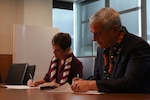 Kelly McKeague, director of the Defense POW/MIA Accounting Agency and Wendy Hensel, the University of Hawaii President sign an education partnership agreement