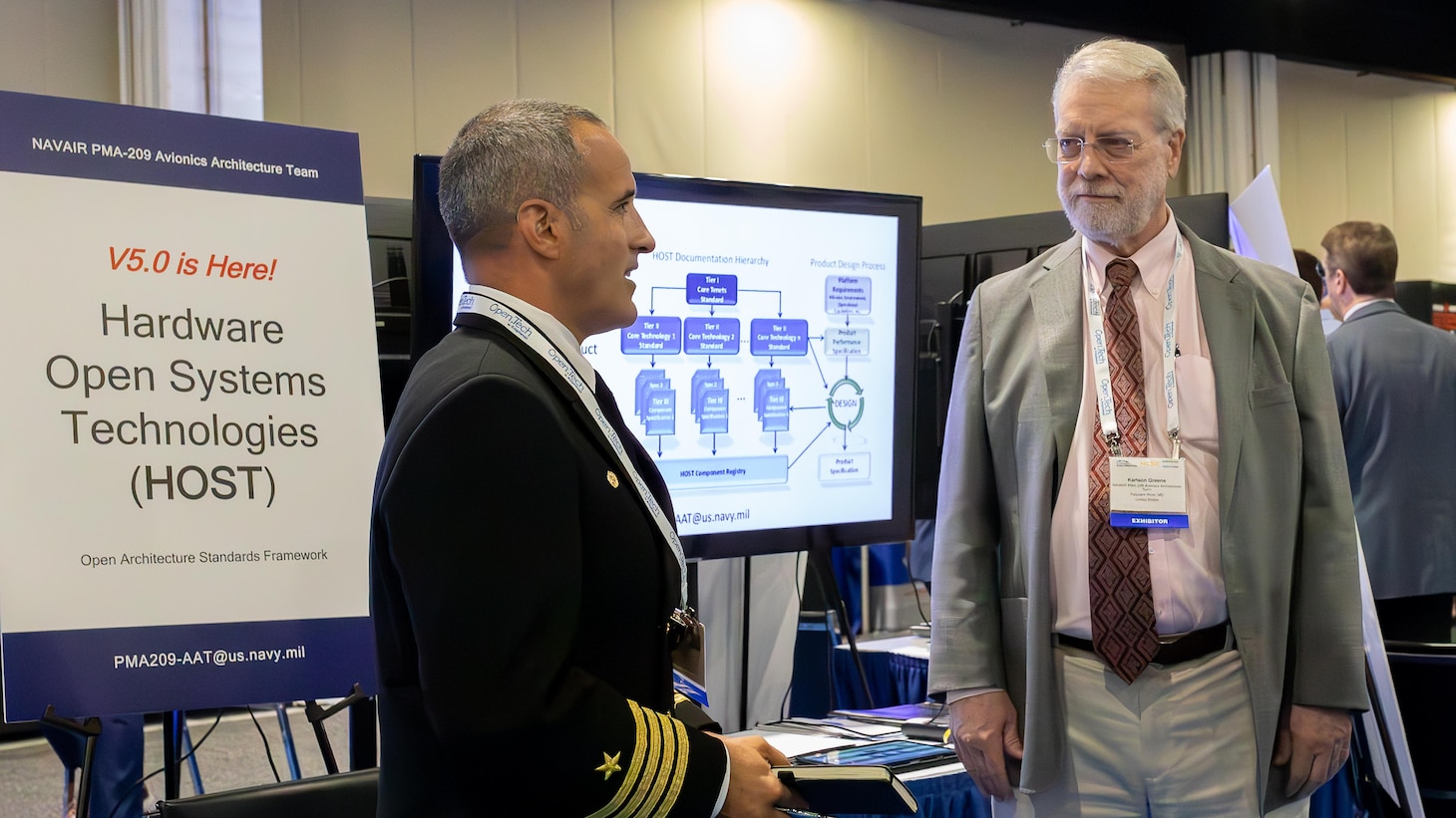 Capt. Jarrod Hair, left, Air Combat Electronics Program Office program manager, speaks with Karlson Greene about the importance of a modular open systems approach (MOSA) and collaboration during the MOSA Summit 2024.