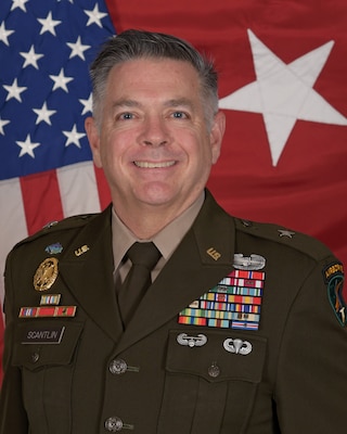 Brig. Gen. Marshall Straus Scantlin poses in his US Army dress uniform in front of the US flag and one-star general flag
