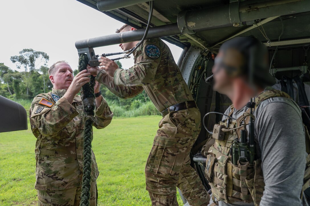 U.S. Army Sgt. 1st Class Paul A. Bonhert, left, and Sgt. Chris Schreerer, center, 1st Battalion, 228th Aviation Regiment crew chiefs, set up a rope, as a Naval Special Warfare operator watches, during PANAMAX-Alpha Phase I, at Cerro Tigre, Panama, July 15, 2025. During their training, Panamanian special forces members trained on utilizing the fast rope insertion/extraction system, enhancing their efficiency for any future operations. (U.S. Air Force photo by Staff Sgt. Sadie Colbert)