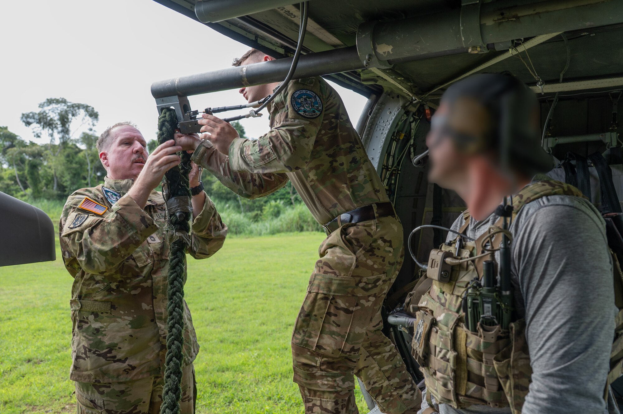 U.S. Army Sgt. 1st Class Paul A. Bonhert, left, and Sgt. Chris Schreerer, center, 1st Battalion, 228th Aviation Regiment crew chiefs, set up a rope, as a Naval Special Warfare operator watches, during PANAMAX-Alpha Phase I, at Cerro Tigre, Panama, July 15, 2025. During their training, Panamanian special forces members trained on utilizing the fast rope insertion/extraction system, enhancing their efficiency for any future operations. (U.S. Air Force photo by Staff Sgt. Sadie Colbert)