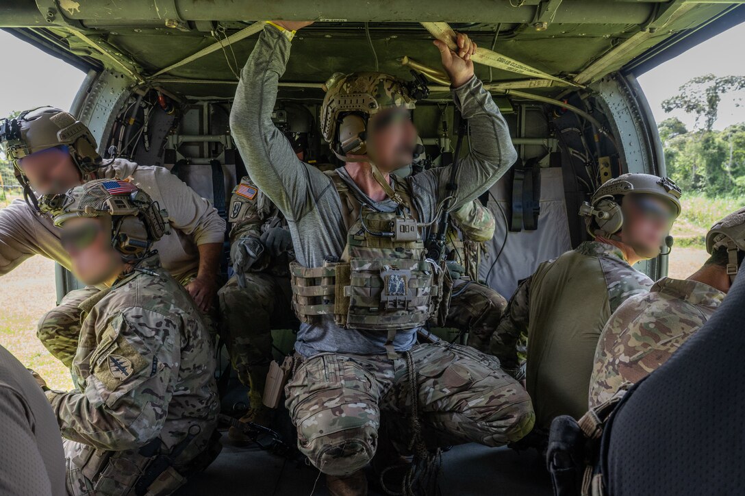 Several U.S. Naval Special Warfare operators prepare to descend from a UH-60 Blackhawk assigned to 1st Battalion, 228th Aviation Regiment, out of Soto Cano Air Base, Honduras, during PANAMAX-Alpha Phase I, at Cerro Tigre, Panama, July 15, 2025. PANAMAX is an annual joint exercise designed to enhance interoperability among participating nations and strengthen their ability to conduct multinational operations, particularly to defend the Panama Canal. (U.S. Air Force photo by Staff Sgt. Sadie Colbert)