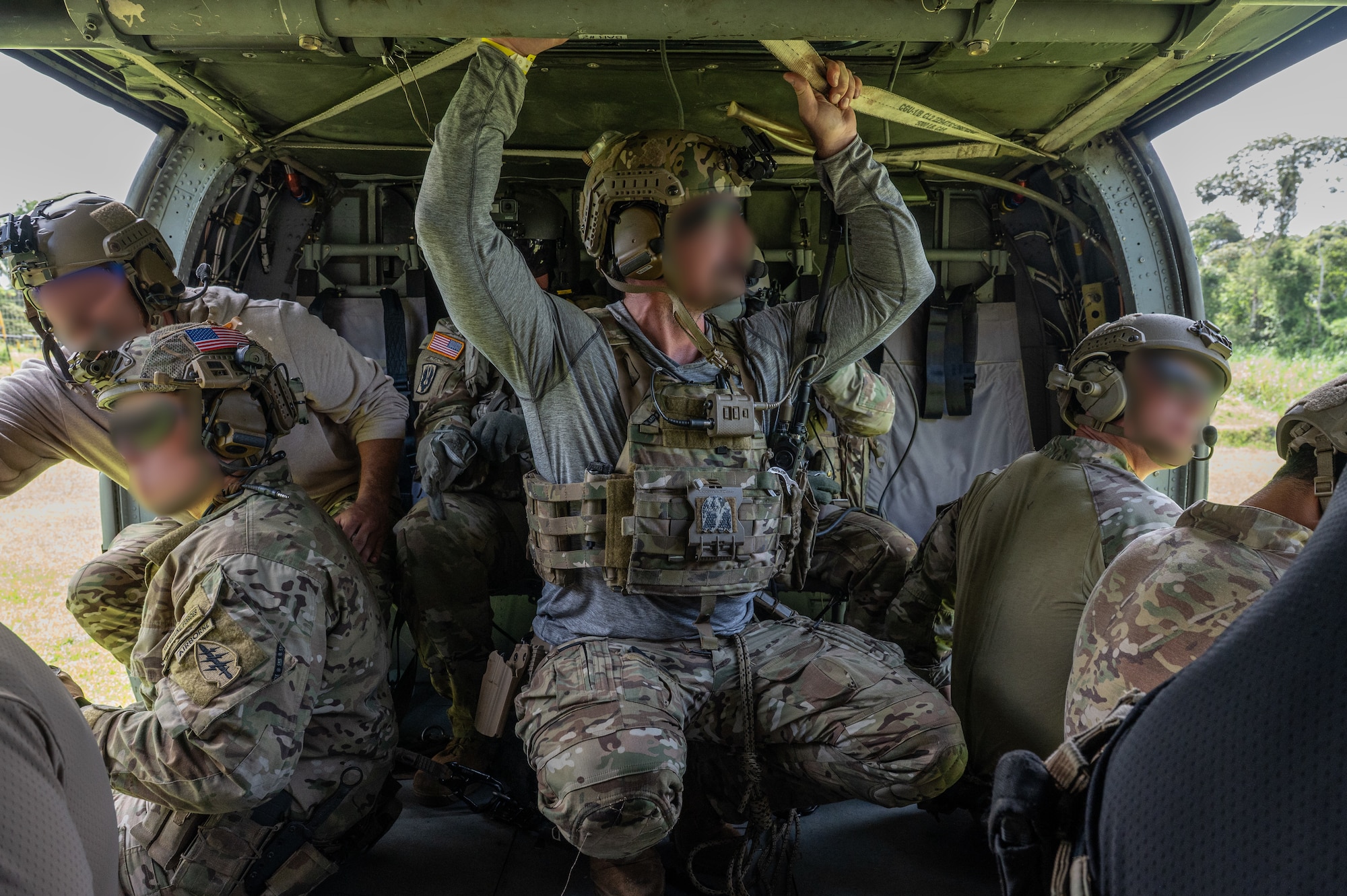 Several U.S. Naval Special Warfare operators prepare to descend from a UH-60 Blackhawk assigned to 1st Battalion, 228th Aviation Regiment, out of Soto Cano Air Base, Honduras, during PANAMAX-Alpha Phase I, at Cerro Tigre, Panama, July 15, 2025. PANAMAX is an annual joint exercise designed to enhance interoperability among participating nations and strengthen their ability to conduct multinational operations, particularly to defend the Panama Canal. (U.S. Air Force photo by Staff Sgt. Sadie Colbert)