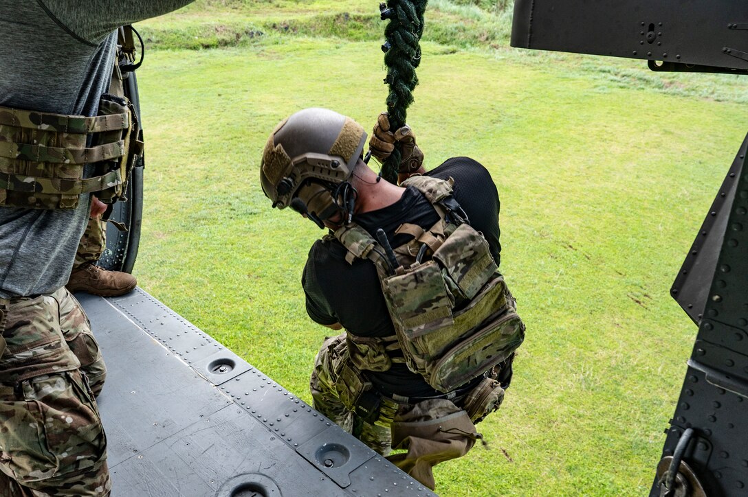 A U.S. Naval Special Warfare operator descends from a UH-60 Blackhawk assigned to 1st Battalion, 228th Aviation Regiment, out of Soto Cano Air Base, Honduras, during PANAMAX-Alpha Phase I, at Cerro Tigre, Panama, July 15, 2025. PANAMAX-Alpha Phase I is a government of Panama exercise supported by U.S. Southern Command, focused on security of the canal in Panama. The portion JTF-Bravo is participating in for phase one includes providing hot and cold load training, K-9 familiarization and hoist training, medical evacuation, fast rope insertion and aerial overwatch training with our helicopters and partners. (U.S. Air Force photo by Staff Sgt. Sadie Colbert)