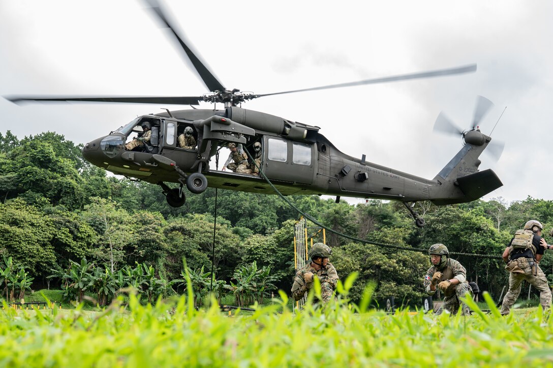 A UH-60 Blackhawk assigned to 1st Battalion, 228th Aviation Regiment, out of Soto Cano Air Base, Honduras, hovers as U.S. and Panamanian special forces service members secure a rope during PANAMAX-Alpha Phase I, at Cerro Tigre, Panama, July 15, 2025. PANAMAX is an annual joint exercise designed to enhance interoperability among participating nations and strengthen their ability to conduct multinational operations, particularly to defend the Panama Canal. (U.S. Air Force photo by Staff Sgt. Sadie Colbert)