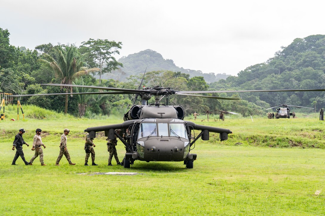U.S. and Panamanian special forces service members walk onto a UH-60 Blackhawk assigned to 1st Battalion, 228th Aviation Regiment, out of Soto Cano Air Base, Honduras, hovers as U.S. and Panamanian special forces service members secure a rope during PANAMAX-Alpha Phase I, at Cerro Tigre, Panama, July 15, 2025. PANAMAX is a joint exercise designed to enhance interoperability among participating nations and strengthen their ability to conduct multinational operations, particularly to defend the Panama Canal. (U.S. Air Force photo by Staff Sgt. Sadie Colbert)