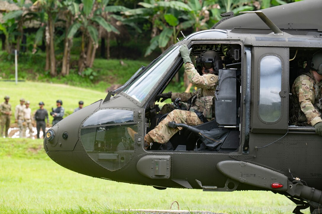 U.S. Army Chief Warrant Officer 2 Cody Griffin, 1st Battalion, 228th Aviation Regiment pilot, waits for U.S. and Panamanian special forces members to get into a UH-60 Blackhawk during PANAMAX-Alpha Phase I, at Cerro Tigre, Panama, July 15, 2025. Supporting many regional missions, Joint Task Force-Bravo provided aircraft and crew for hot and cold load training, K-9 familiarization and hoist training, medical evacuation, fast rope insertion and aerial overwatch training with our helicopters and partners. (U.S. Air Force photo by Staff Sgt. Sadie Colbert)