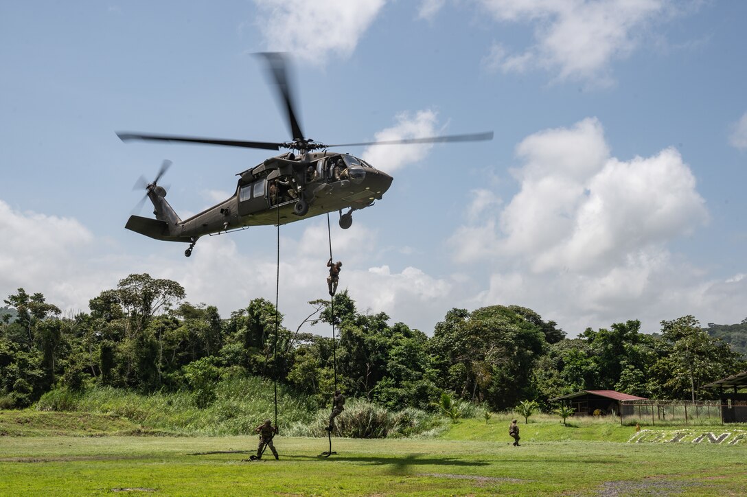 U.S. Naval Special Warfare operators and Panamanian special forces fast-rope down from a UH-60 Blackhawk during PANAMAX-Alpha Phase I, at Cerro Tigre, Panama, July 15, 2025. PANAMAX is a joint exercise designed to enhance interoperability among participating nations and strengthen their ability to conduct multinational operations, particularly to defend the Panama Canal. (U.S. Air Force photo by Staff Sgt. Sadie Colbert)