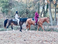 Jasmine McKinney, left, a defense enrollment eligibility reporting system technician with the 11th Force Support Squadron, rides a horse with her sister, Jacqueela Mason, right, during a horseback riding session in Waldorf, Maryland in fall 2024. Retired U.S. Air Force Chief Master Sgt. Fredrick Edison, deputy director for the Military Personnel Flight with the11th FSS, created his horseback riding mission, Freddy’s Heavenly Gaits, to support wellness for Airmen. (U.S. Air Force courtesy photo)