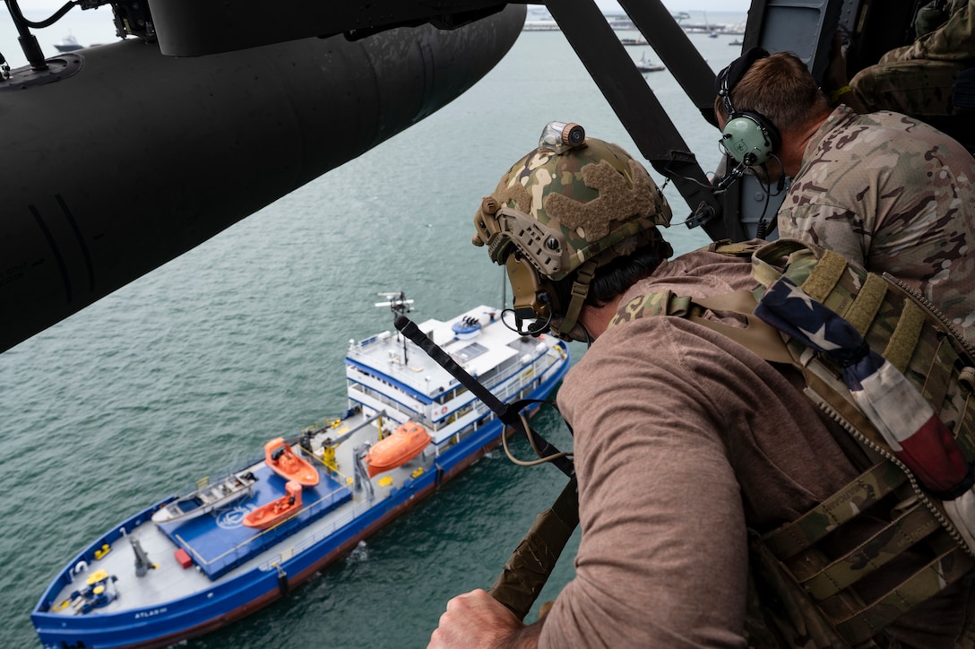 Two U.S. Naval Special Warfare operators spectate a simulated visit, board, search, and seizure training during PANAMAX-Alpha Phase I, at Panama City, Panama, July 16, 2025. The portion JTF-Bravo is participating in for phase one includes providing hot and cold load training, K-9 familiarization and hoist training, medical evacuation, fast rope insertion and aerial overwatch training with our helicopters and partners. (U.S. Air Force photo by Staff Sgt. Sadie Colbert)